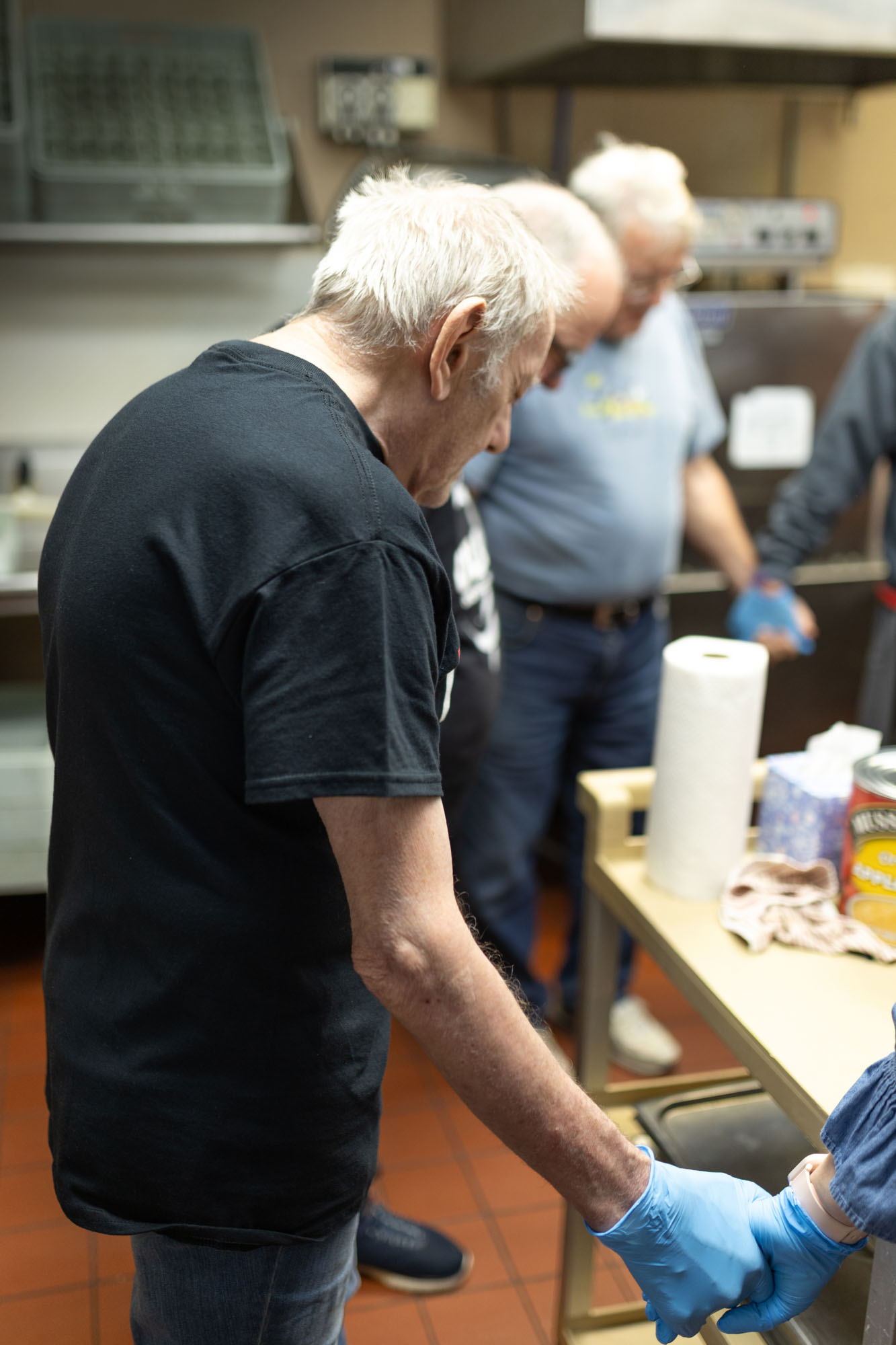 George Boychock holds hands and prays with others before his shift in the kitchen at The Salvation Army. 